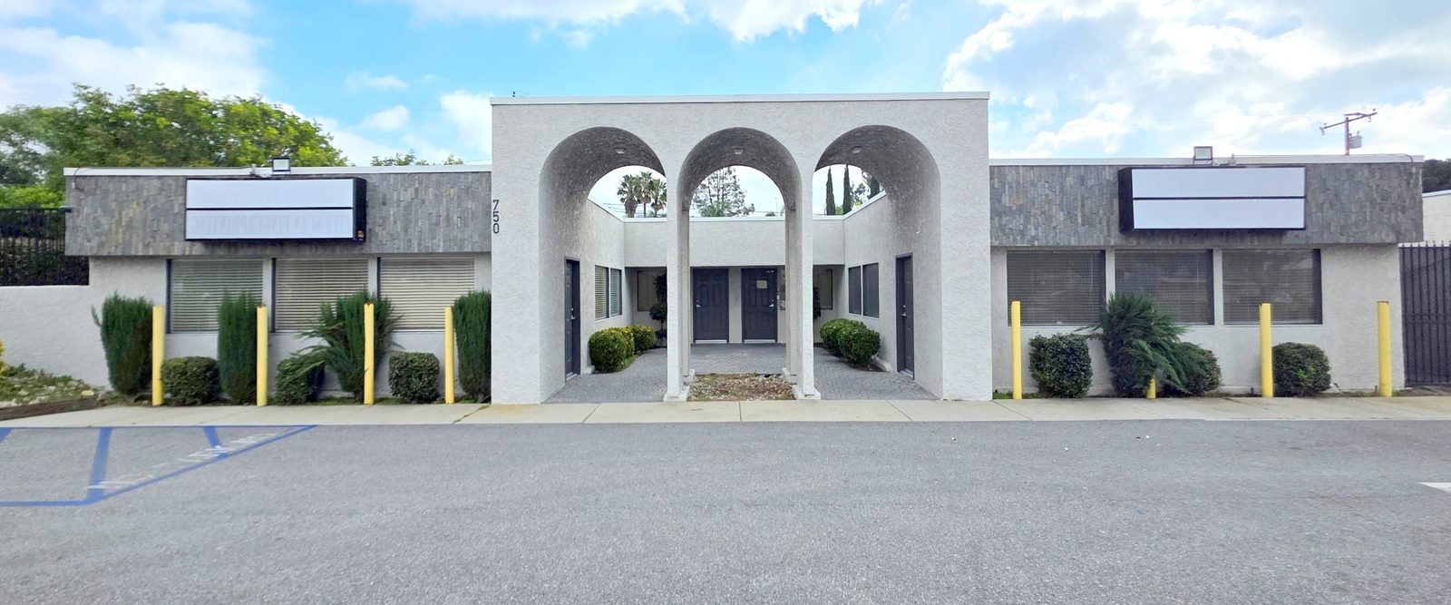 The single-story medical building at 750 N Mountain Ave, Upland — white stucco with three arches over a central courtyard, and parking directly in front