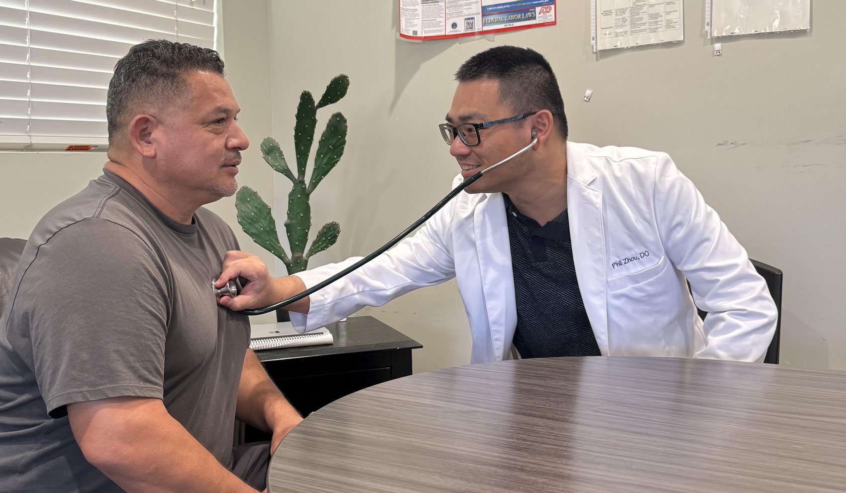 El Dr. Phil Zhou examinando a un paciente en el consultorio